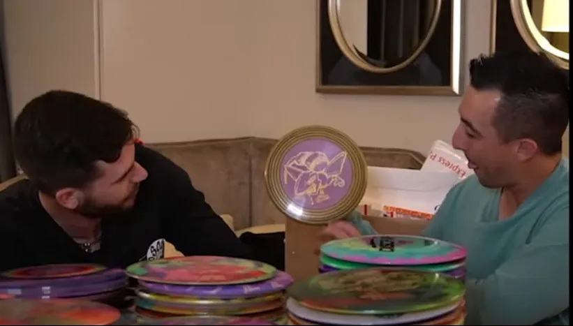 Paul McBeth holding one of my hand-dyed discs, with stacks of custom dyed discs on the table